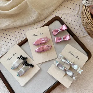 Set di fermagli per capelli con fiocchi rosa e argento per bambine su un vassoio di legno