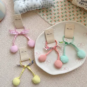 Lot de quatre chouchous nœuds cerises colorés pour filles sur une assiette décorée