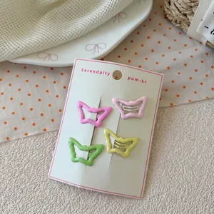 Detailed view of four colorful butterfly metal hair clips on a white display card