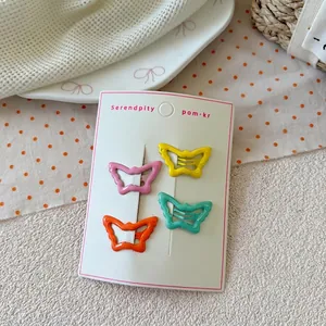 Detailed view of four colorful butterfly metal hair clips on a white display card