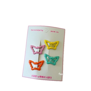 Set of four colorful butterfly hair clips in pink yellow orange and green on display card