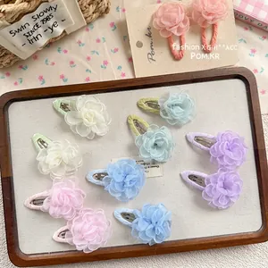Floral chiffon hair clips set for girls in assorted colors displayed on wooden tray