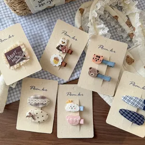 Set di graziose mollette in tessuto per bambine con ricami e motivi a quadretti