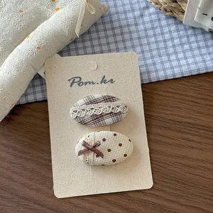 Dettaglio di fermagli per capelli in tessuto stile coreano per bambine su carta da esposizione