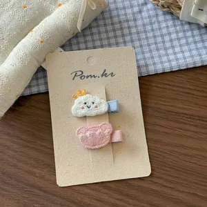 Dettaglio delle mollette ricamate con nuvola bianca e orsetto rosa per bambine