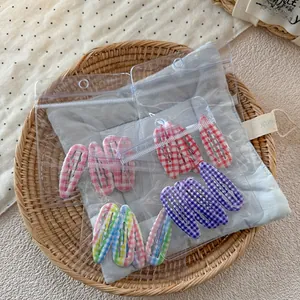 Détail des pinces à cheveux BB à carreaux colorés au design ondulé et emballage
