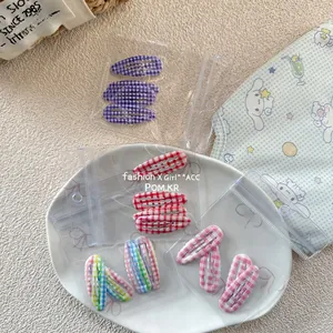 Détail de l'ensemble de barrettes BB à carreaux colorés dans un emballage zippé