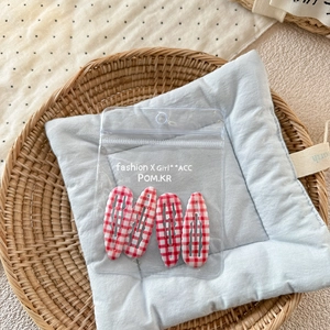 Lot de quatre barrettes à cheveux à carreaux rouges dans un sachet transparent