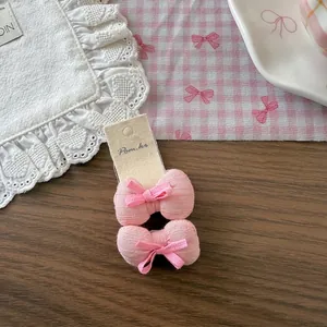 Macro de barrettes à nœuds roses en tissu pour filles sur carte de présentation beige