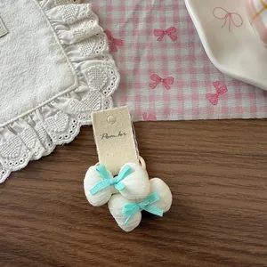 Détail de chouchous en tissu en forme de cœur avec nœuds en soie bleue et étiquette
