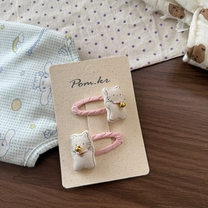 Close-up of pink cat bow hair clips with soft fabric and small bell decorations