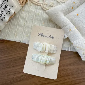Gros plan détaillé de deux pinces à cheveux en tissu de style coréen sur carte support