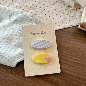 Detail of purple plaid and yellow heart embroidery fabric hair clips for kids on card