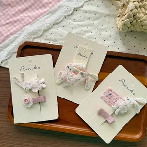 Detail von rosa bestickter Hasen-Haarklammer und floralem Haarschmuck mit Spitze für Mädchen