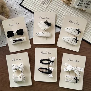 Set van zes Koreaanse haarclips met zwart-witte stippen en strikken op displaykaart