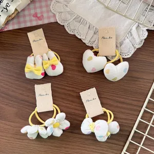 Floral fabric hair ties for girls with rabbit, heart, flower, and bow shapes on wood