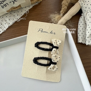 Detailopname van zwart-witte haarspelden met polkadots op een decoratieve displaykaart