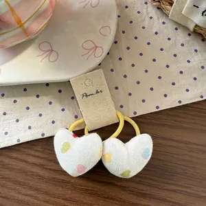Close-up of two heart-printed fabric hair ties with high elastic yellow bands