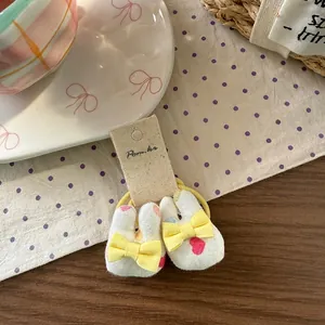 Detail of cute plush bunny hair ties with heart prints and yellow bows on card