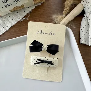 Detail van zoete haarclipset met strik en stippen op een presentatiekaart