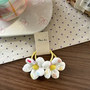 Detailed macro view of children floral hair ties with heart patterns on a ceramic plate