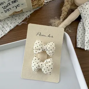 Detailopname van twee crème haarstrikken met zwarte stippen op een displaykaart
