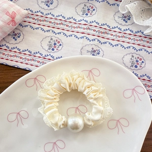 Detail von creme-ballett spitzen-scrunchie mit satin-textur und weißem perlen-akzent