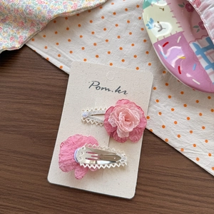 Detail of pink gradient chiffon flower hair clips with lace and pearls on a card