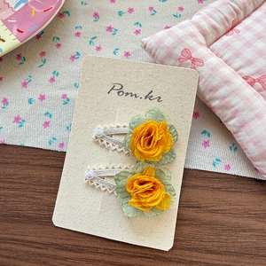 Detail of yellow chiffon rose hair clips with lace and pearls on display card