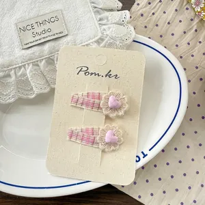 Détail de pinces à cheveux en dentelle florale pour filles avec motif à carreaux roses