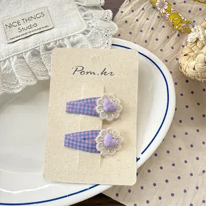 Détail de barrettes en dentelle florale et tissu à carreaux sur une assiette décorative