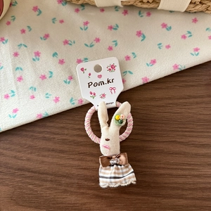 Détail d'un chouchou lapin en tissu mignon avec robe à carreaux sur élastique rose