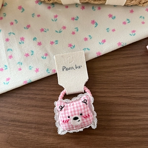 Détail de l'élastique à cheveux ours à carreaux roses avec dentelle et broderie