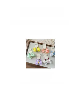 Detailansicht der handgefertigten Spitzen-Haarschleifen mit kleiner Blume für Mädchen
