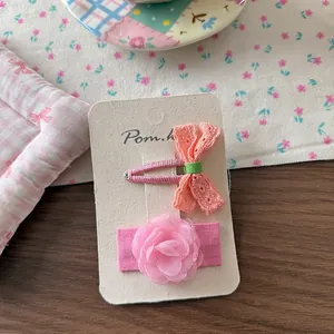 Detail of pink lace bow hairpin and chiffon flower clip set on a display card