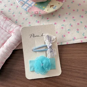 Detail of blue lace floral bow hair clips and mesh flower pins set on display card