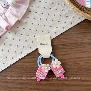 Detailed close-up of handmade pink knitted ice cream hair ties with colorful beads