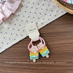 Detail of pink floral crochet ice cream hair ties for girls on wooden and polka dot fabric