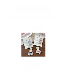 Détail de barrettes et chouchous lapin brodés pour filles sur fond de bois naturel