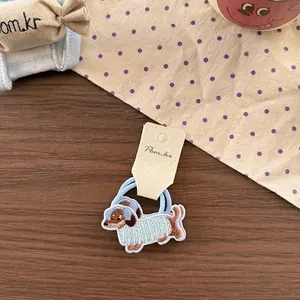 Detail of blue elastic hair tie featuring a cute embroidered dachshund dog patch