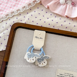 Détail d'élastiques à cheveux bleu clair avec broderie de chiot blanc et petits nœuds