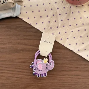 Detail of purple elastic hair ties with cute embroidered elephant and small crown