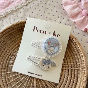 Détails de pinces à cheveux avec broderie lapin, bordure en dentelle et perles sur carte