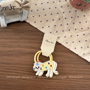 Detail of embroidered cat hair tie with yellow elastic bands on premium wood desk