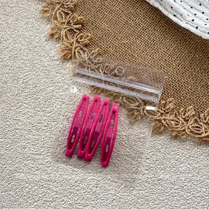 Set of four rose pink metal water-drop hair clips neatly packed in a clear bag