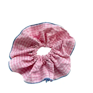 Pink and white striped scrunchie with blue trim edge in a minimalist style hair accessory