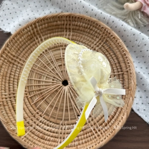 Detailed shot of yellow girls' headband featuring a sequined mini hat and lace veil