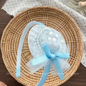 Close-up of light blue glitter sequin top hat headband with pearls and lace mesh detail
