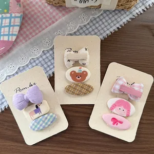 Détail de neuf barrettes en tissu pour filles avec motifs à carreaux et oursons mignons