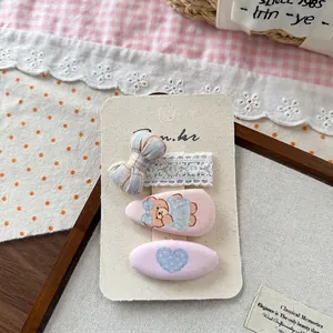 Vue détaillée du lot de trois barrettes à cheveux à nœuds coréens sur carte cadeau